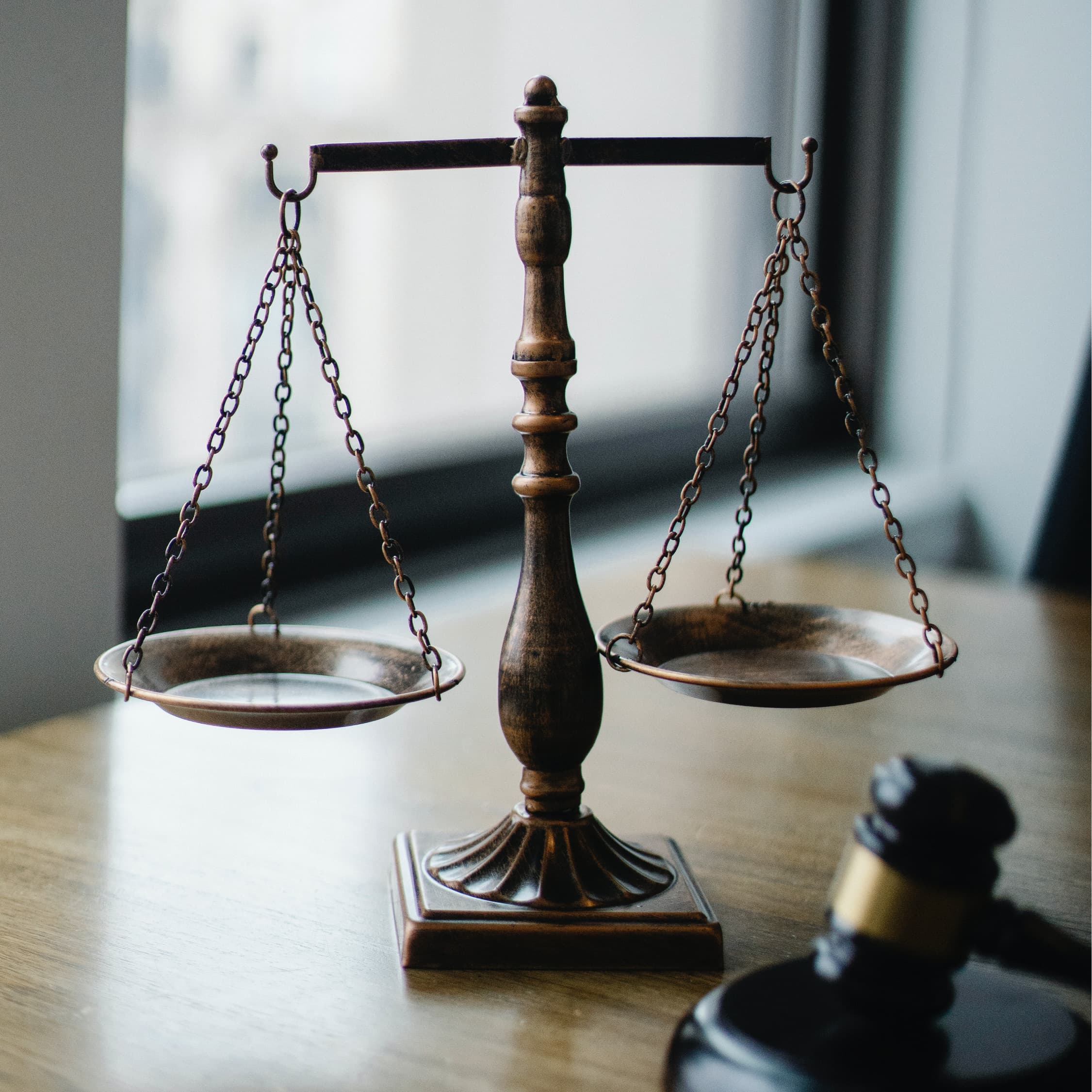 Balanced legal scales with a gavel in the foreground.