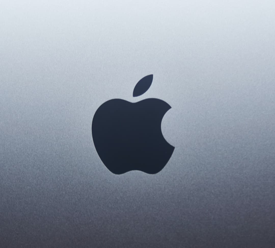 Apple logo on a background that fades from light gray to dark gray.